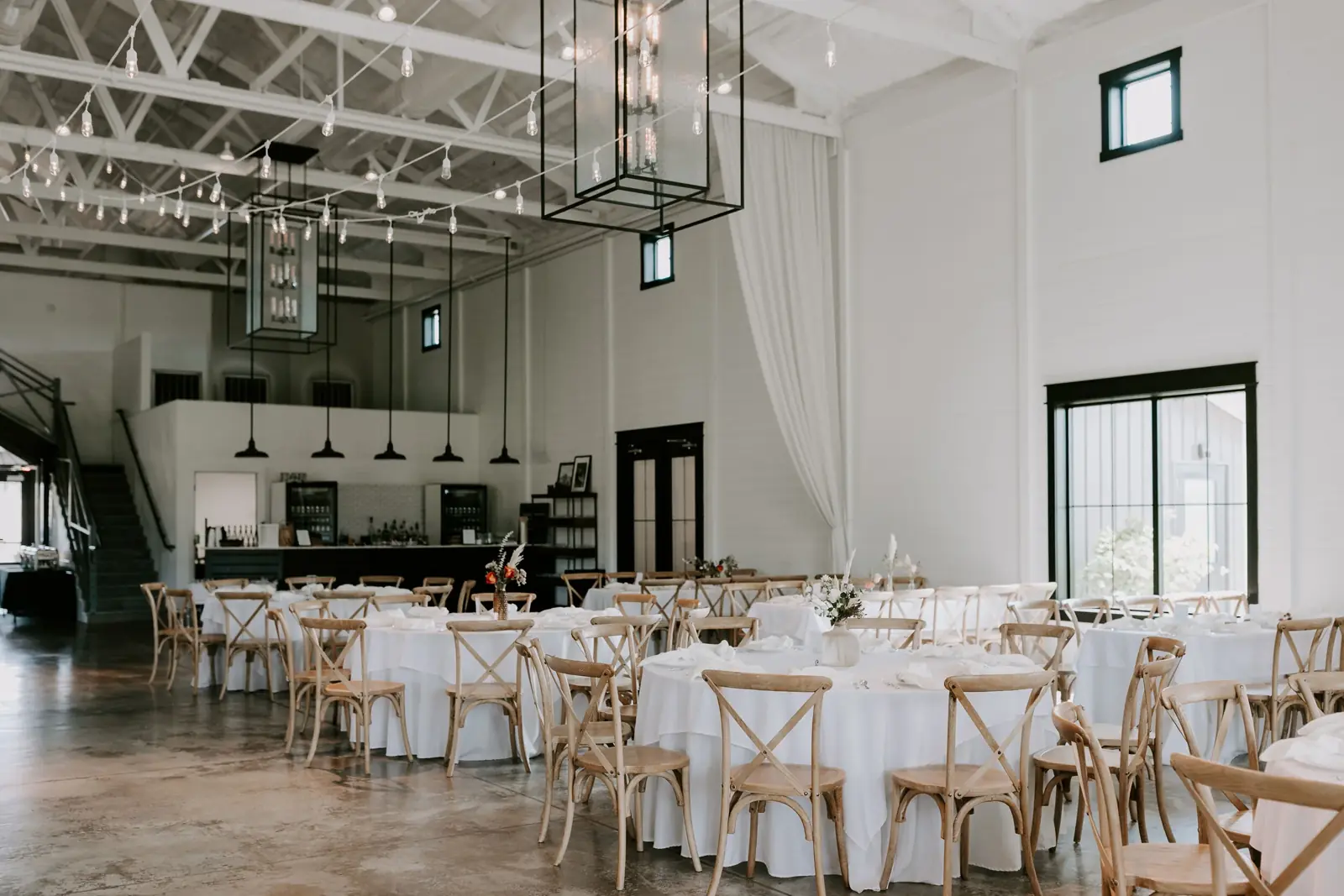 The main hall set for dinner — round tables and cross-back chairs