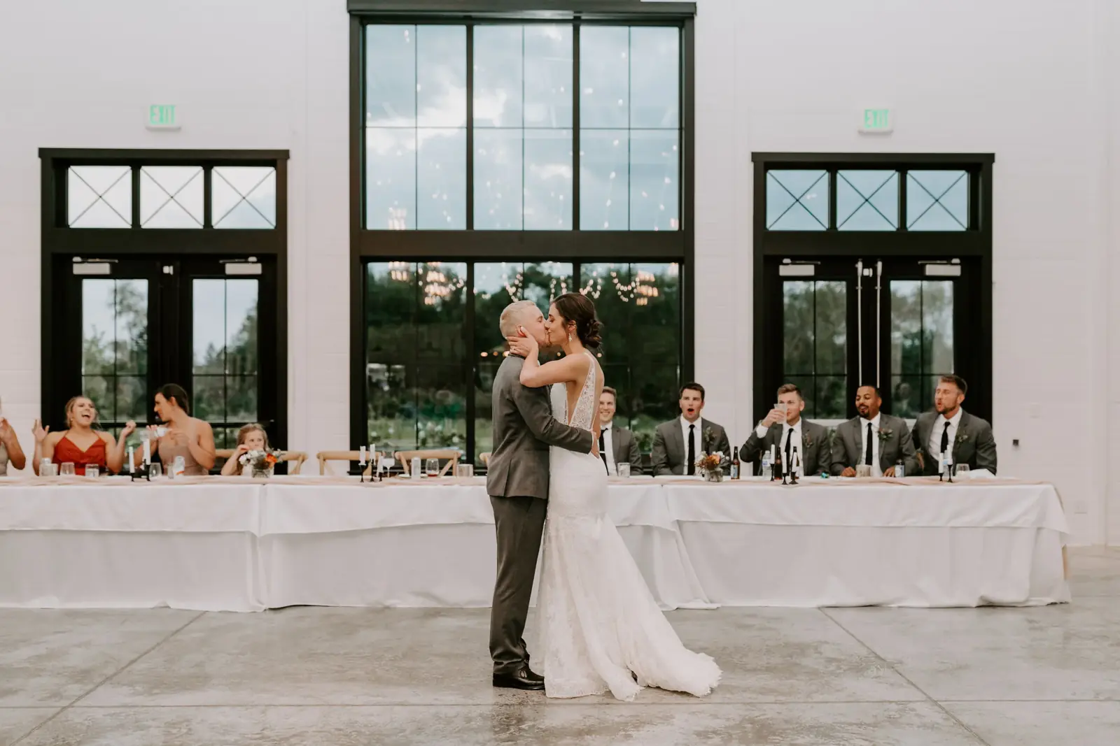 A sweetheart moment in front of the two-story windows