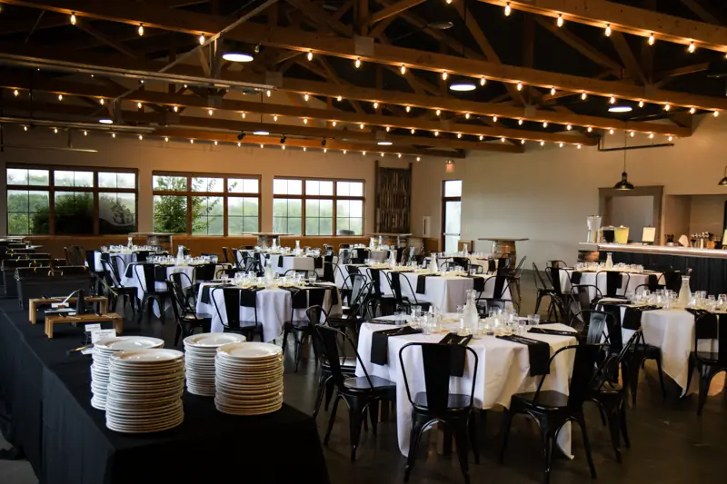 The event center set for a reception, under string lights