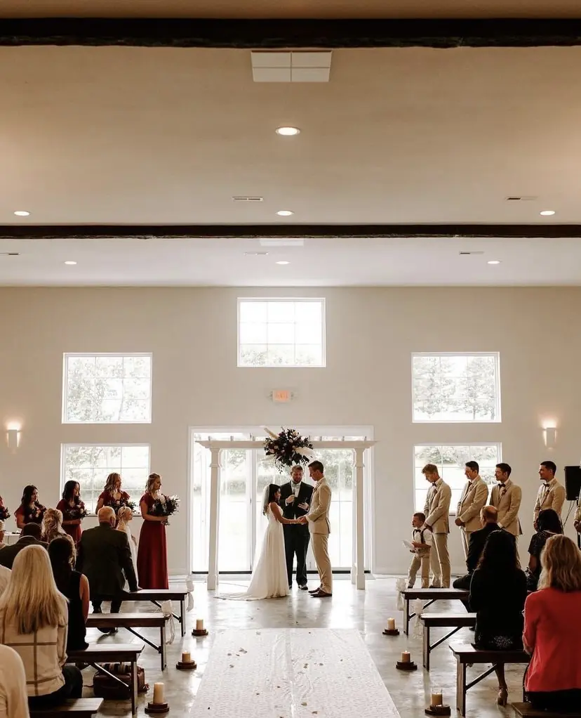 An indoor ceremony under the tall windows