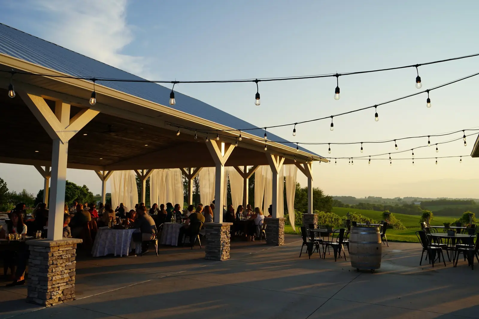 The covered pavilion at dusk under string lights